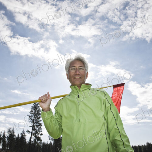 A young asian senior man ready to hit his next golf shot on a golf course.