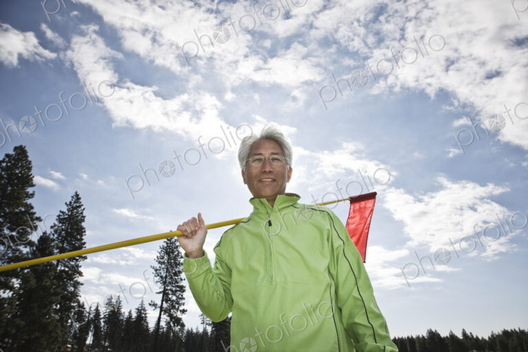 A young asian senior man ready to hit his next golf shot on a golf course.