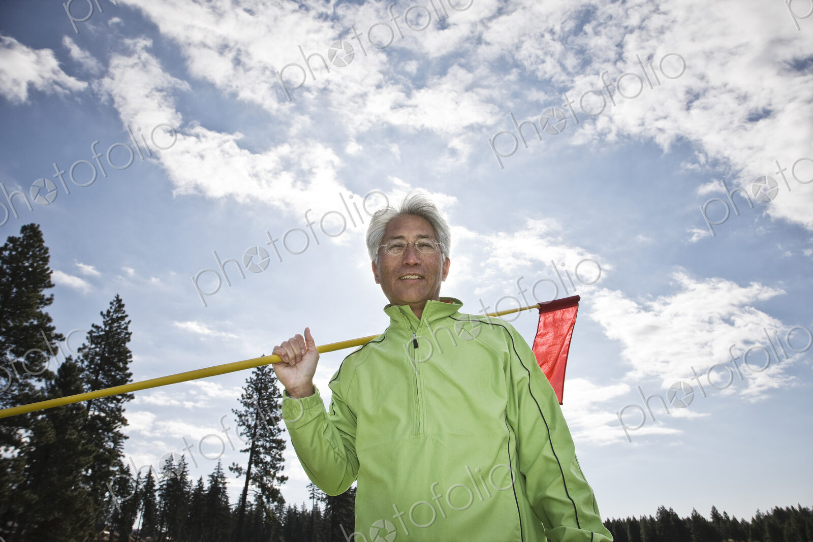 A young asian senior man ready to hit his next golf shot on a golf course.