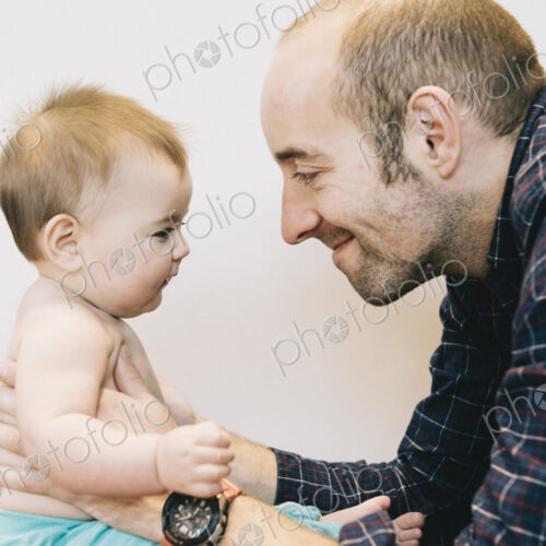 A young baby girl and her father face to face playing. A young baby girl and her father face to face playing.