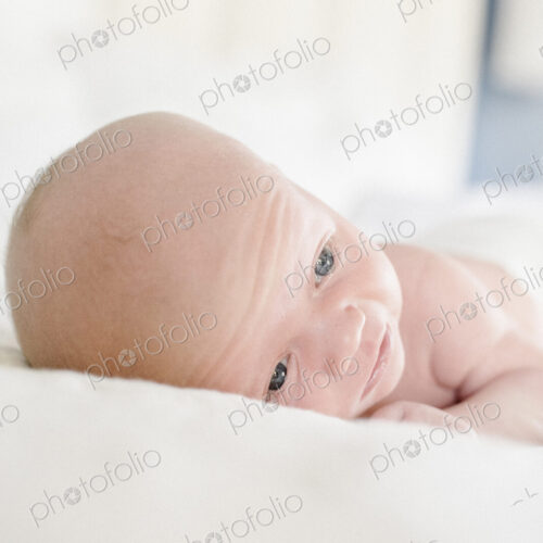 A young baby lying on a bed. A young baby lying on a bed.