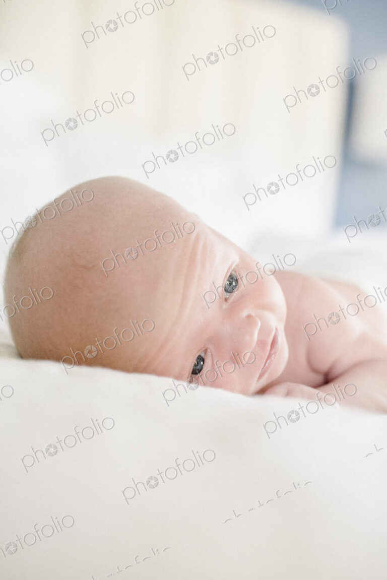 A young baby lying on a bed.