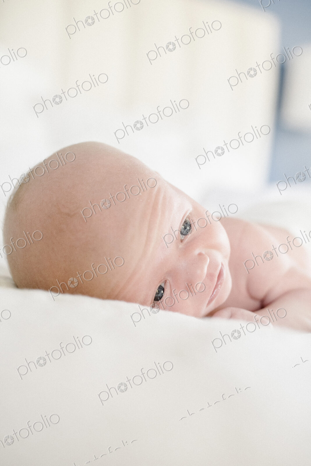 A young baby lying on a bed.
