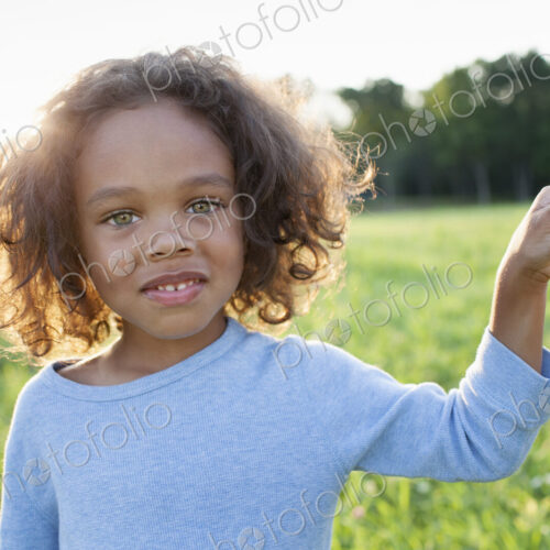 A young boy holding his mother's hand, standing in the grass in a field. A young boy holding his mother's hand, standing in the grass in a field.