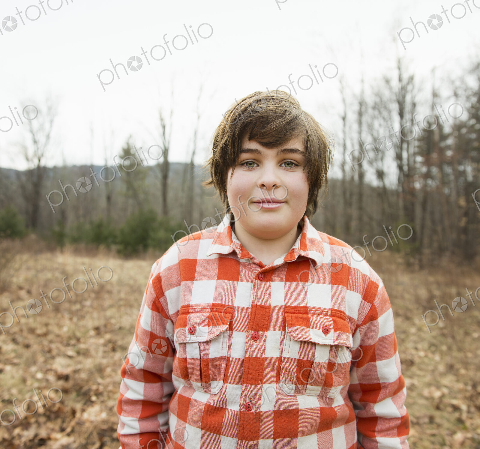 A young boy in a red checked shirt outside on a winter’s day.