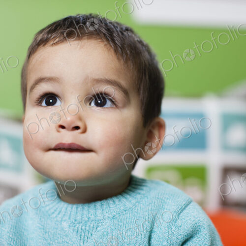 A young boy looking up with an anxious expression on his face. A young boy looking up with an anxious expression on his face.