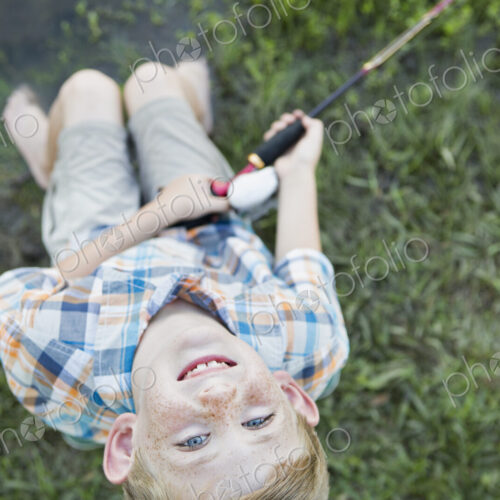 A young boy outdoors looking upwards.