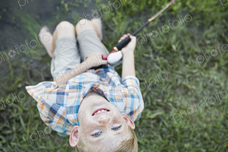 A young boy outdoors looking upwards.