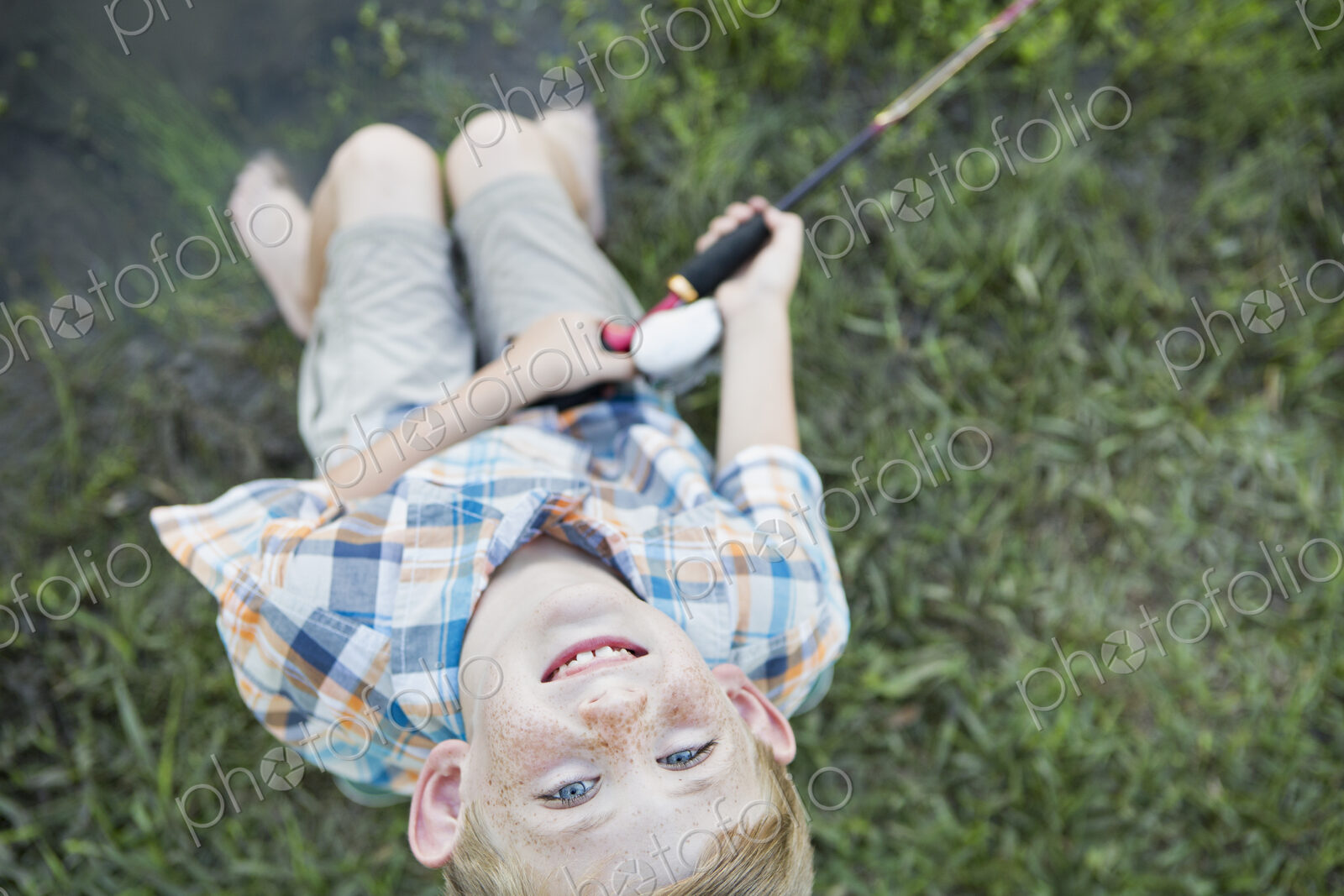 A young boy outdoors looking upwards.