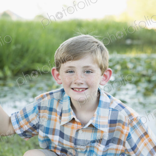 A young boy with his fishing road, by a lake or river. A young boy with his fishing road, by a lake or river.