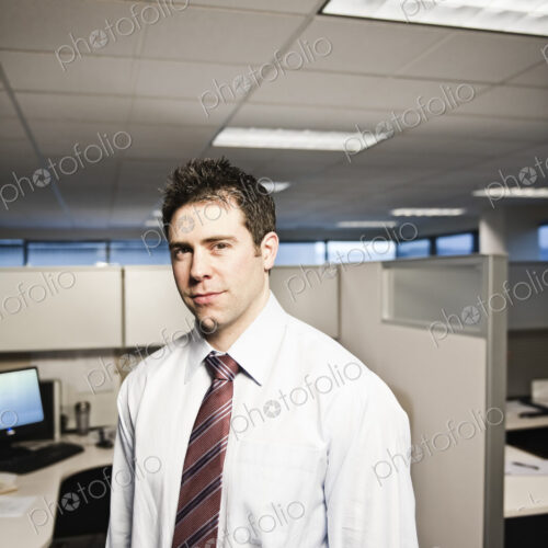 A young caucasian businessman in a shirt and tie in his office.