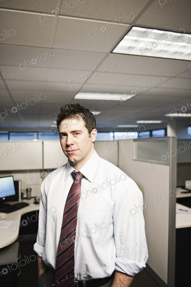 A young caucasian businessman in a shirt and tie in his office.
