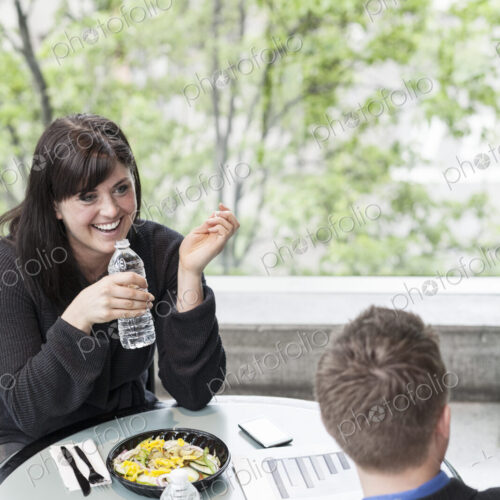 A young caucasian businesswoman having lunch with a businessman. A young caucasian businesswoman having lunch with a businessman.
