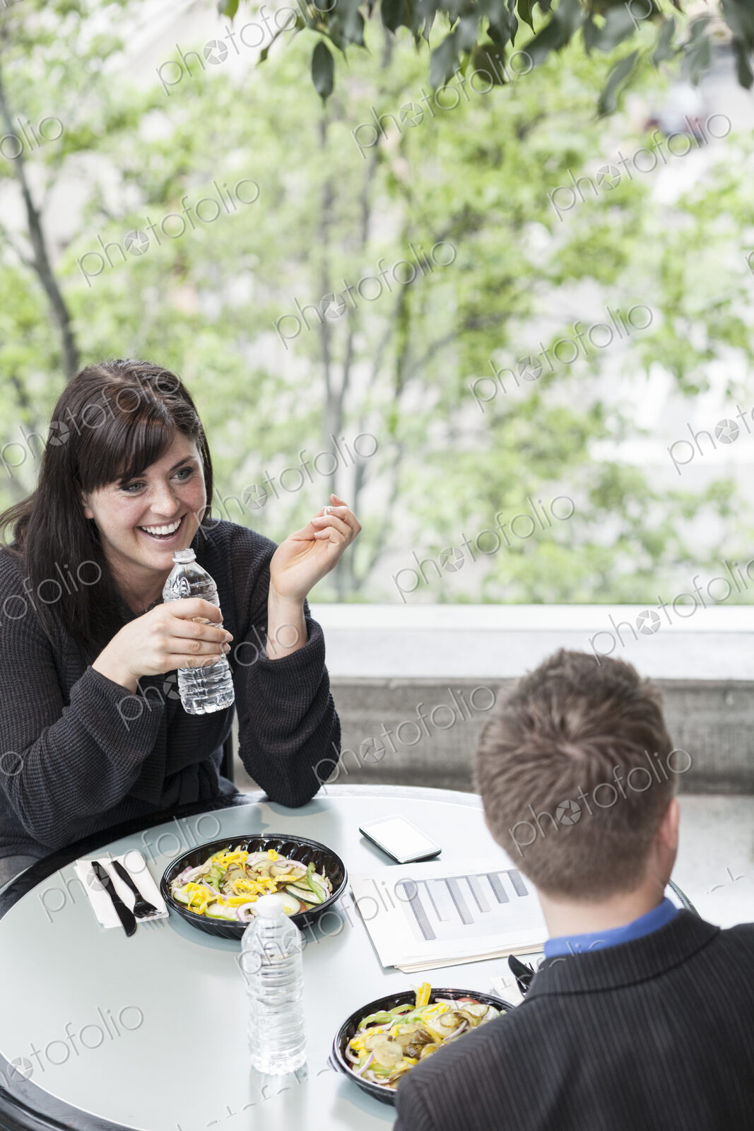 A young caucasian businesswoman having lunch with a businessman.