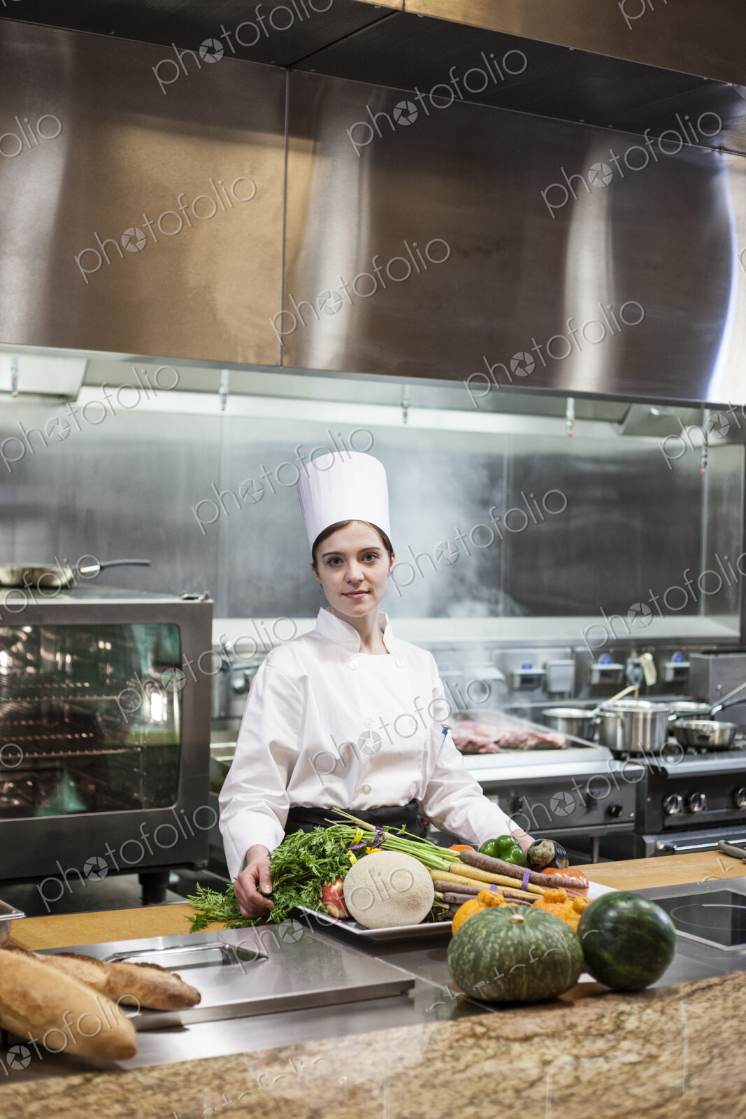 A young caucasian chef working with fresh vegetables in a commercial kitchen,