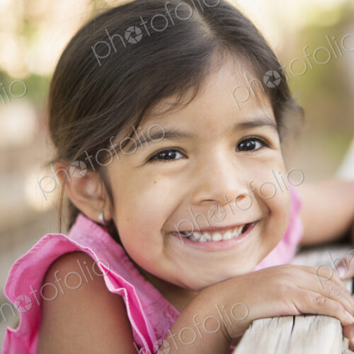 A young child, a girl smiling at the camera. A young child, a girl smiling at the camera.