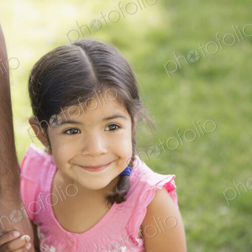 A young child in a pink dress holding her father's hand. A young child in a pink dress holding her father's hand.