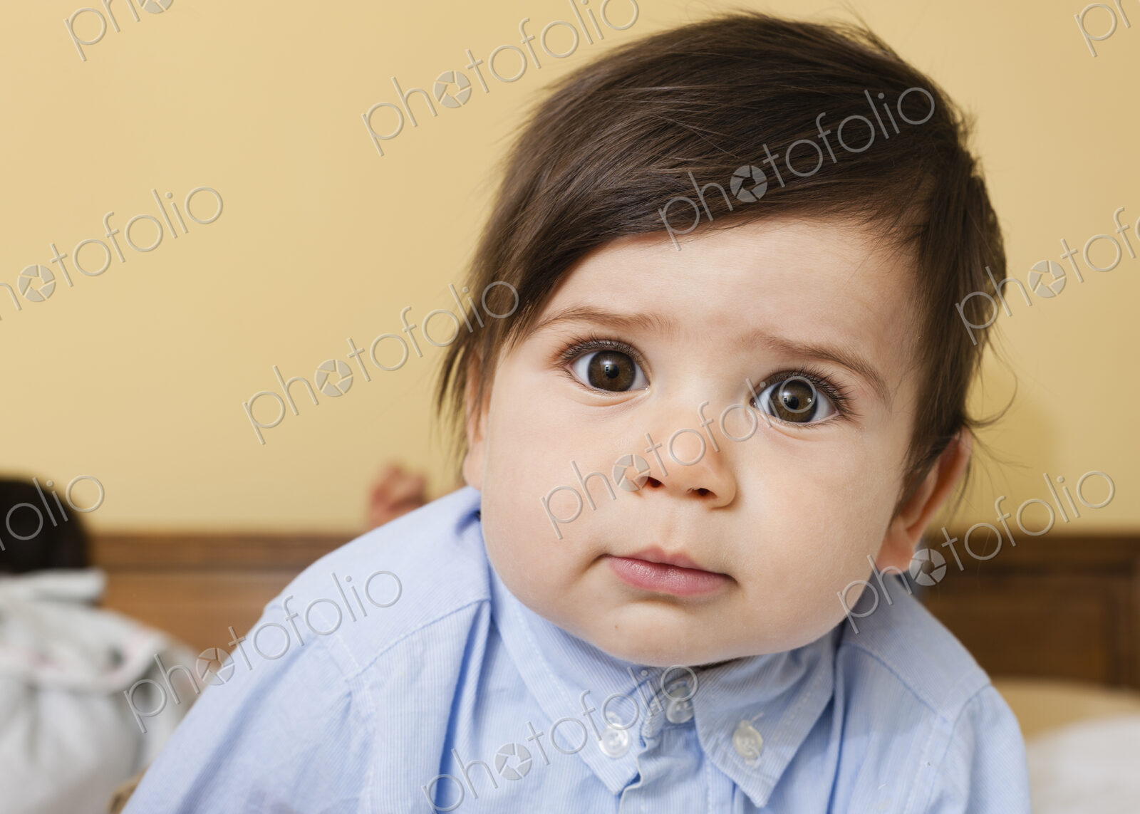 A young child with round eyes, and black hair, looking at the camera.