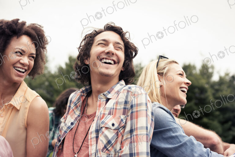A young couple, a man and woman among others outdoors in the countryside.