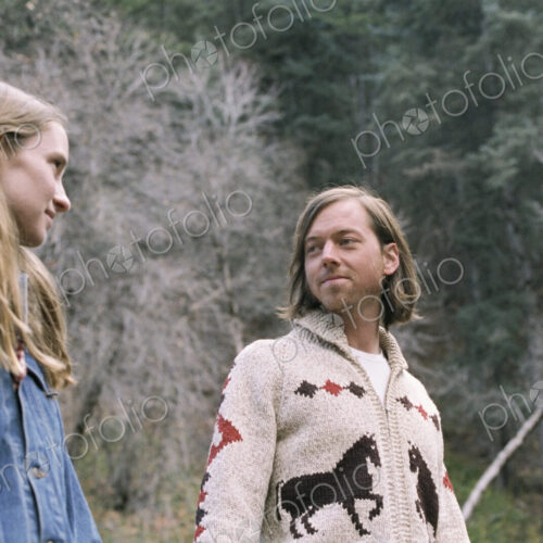 A young couple standing in a forest. A young couple standing in a forest.