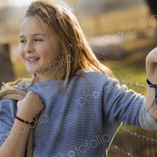 A young girl by a paddock fence. A young girl by a paddock fence.