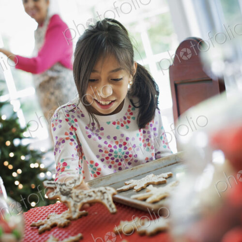 A young girl decorating Christmas cookies with icing. A young girl decorating Christmas cookies with icing.