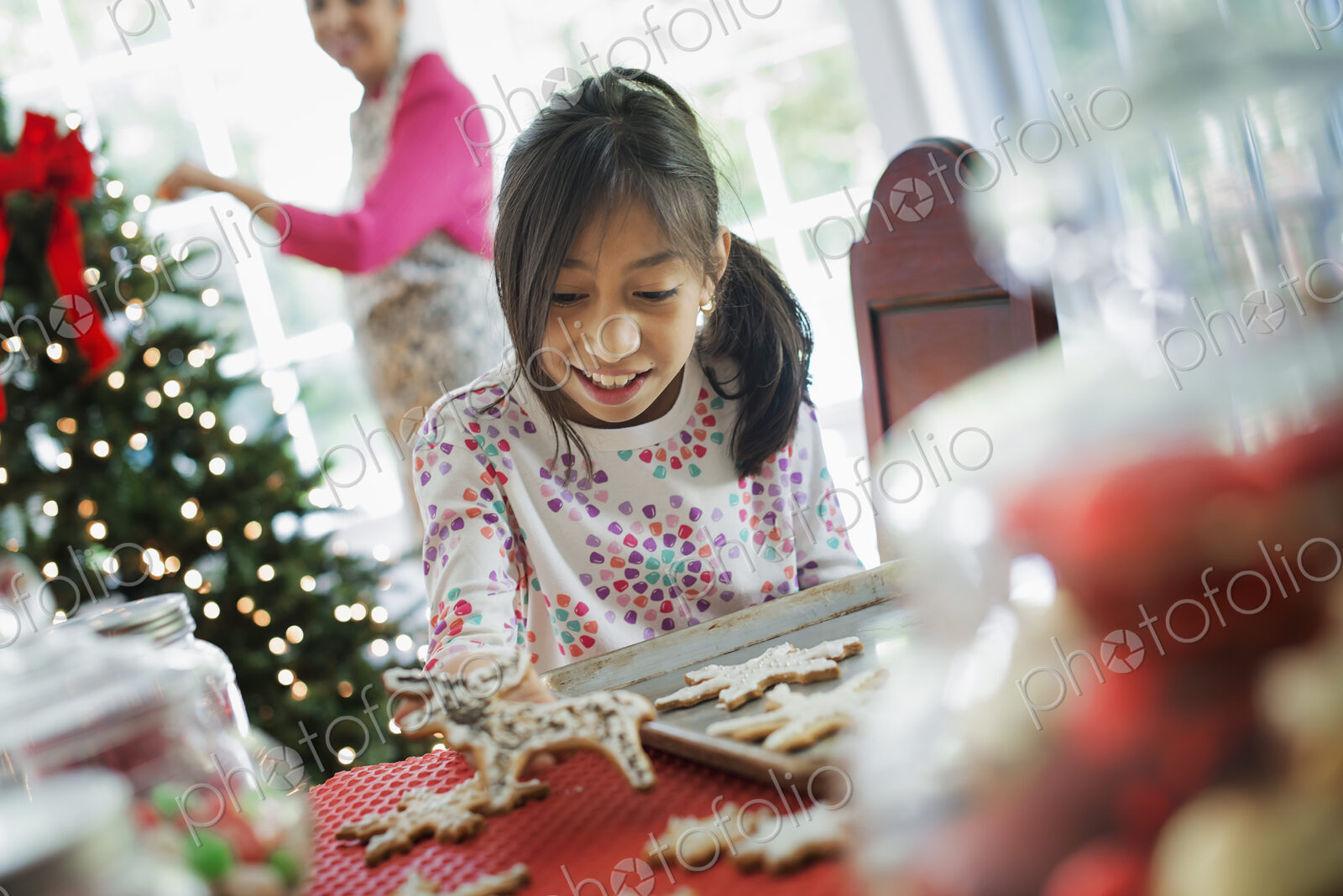 A young girl decorating Christmas cookies with icing.
