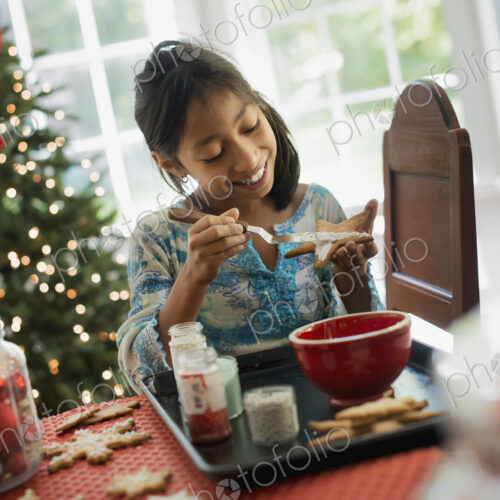 A young girl decorating Christmas cookies with icing. A young girl decorating Christmas cookies with icing.