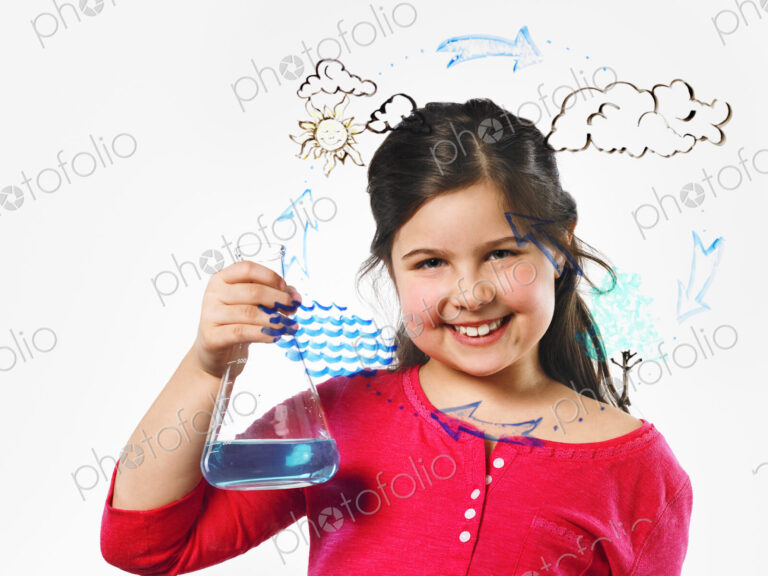 A young girl holding a conical flask of blue liquid in front of an evaporation cycle…