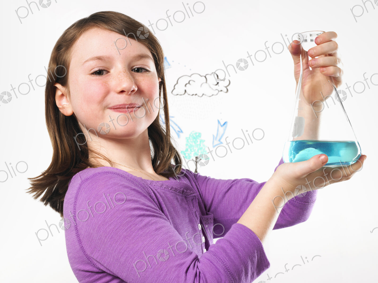 A young girl holding a conical flask of blue liquid in front of an evaporation cycle…