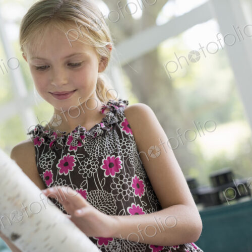 A young girl holding a piece of tree trunk with very white bark. A young girl holding a piece of tree trunk with very white bark.