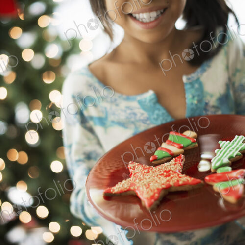A young girl holding a plate of organic decorated Christmas cookies. A young girl holding a plate of organic decorated Christmas cookies.