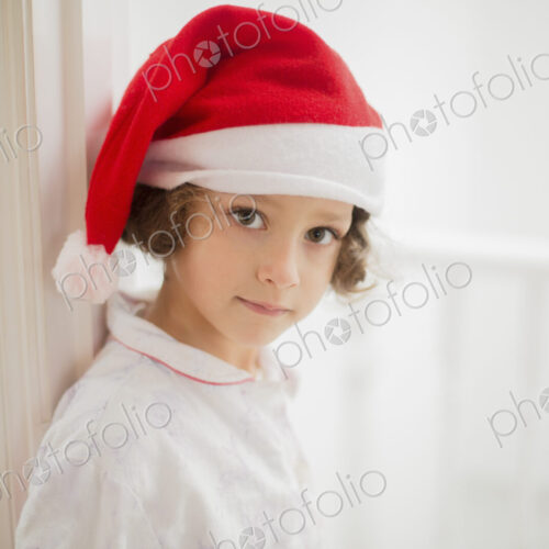 A young girl in a Santa hat on Christmas morning. A young girl in a Santa hat on Christmas morning.