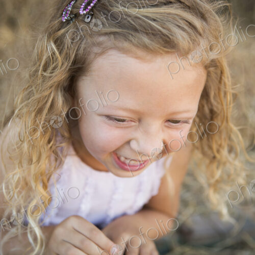 A young girl in a barn laughing. A young girl in a barn laughing.