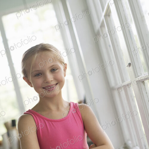 A young girl in a kitchen wearing a pink dress. A young girl in a kitchen wearing a pink dress.