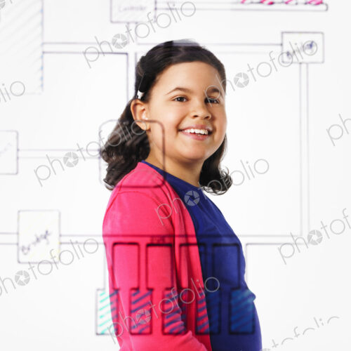 A young girl looking at a drawing of a computer motherboard circuit drawn on a see… A young girl looking at a drawing of a computer motherboard circuit drawn on a see…