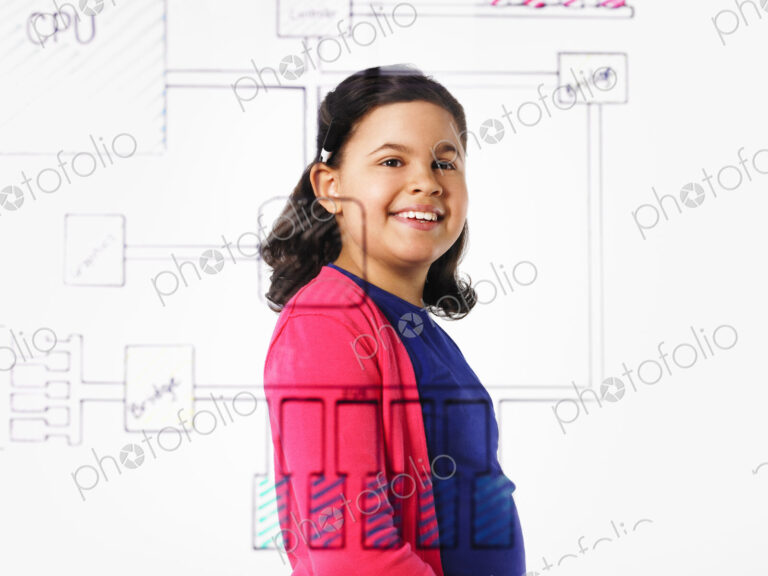 A young girl looking at a drawing of a computer motherboard circuit drawn on a see…