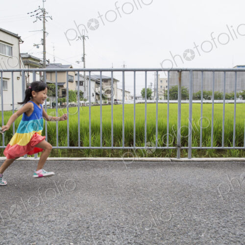 A young girl running along a footpath.