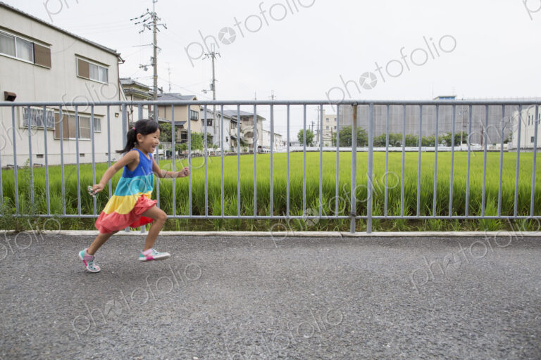 A young girl running along a footpath.