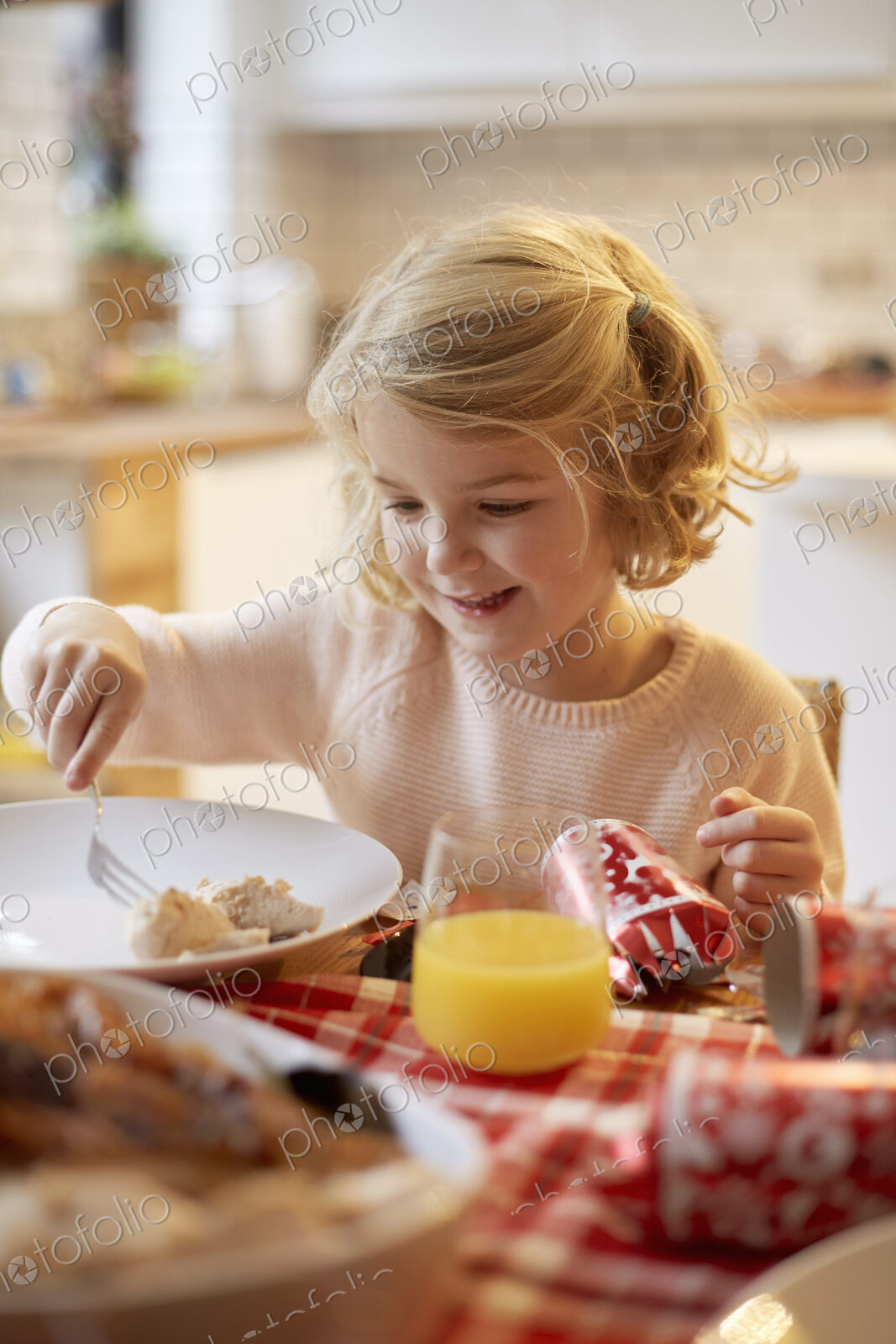 A young girl sitting at a table having a meal.