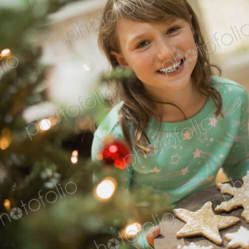 A young girl with a tray of organic baked and iced Christmas cookies.