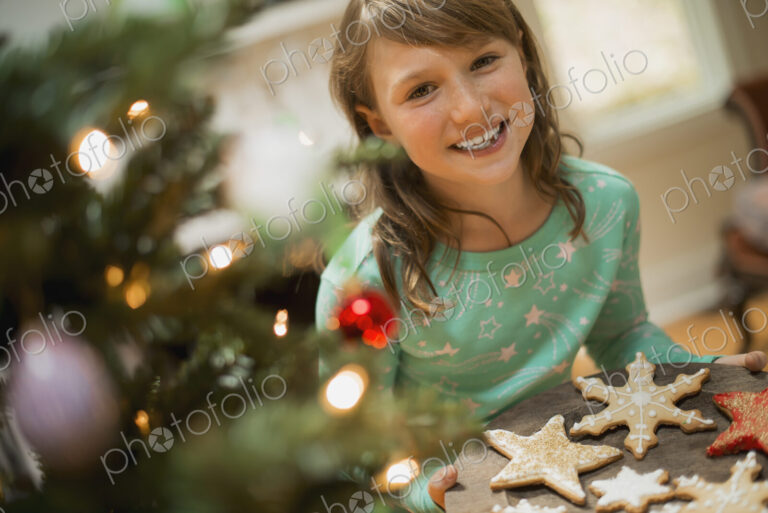 A young girl with a tray of organic baked and iced Christmas cookies.
