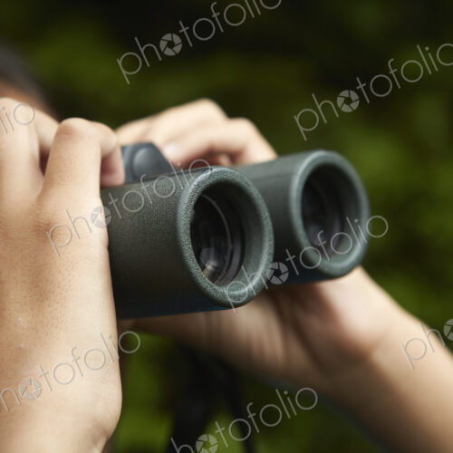 A young girl with bird watching binoculars.