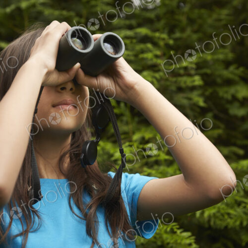 A young girl with bird watching binoculars.