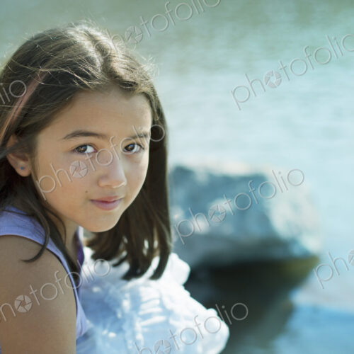 A young girl with long dark hair on the lake shore. A young girl with long dark hair on the lake shore.