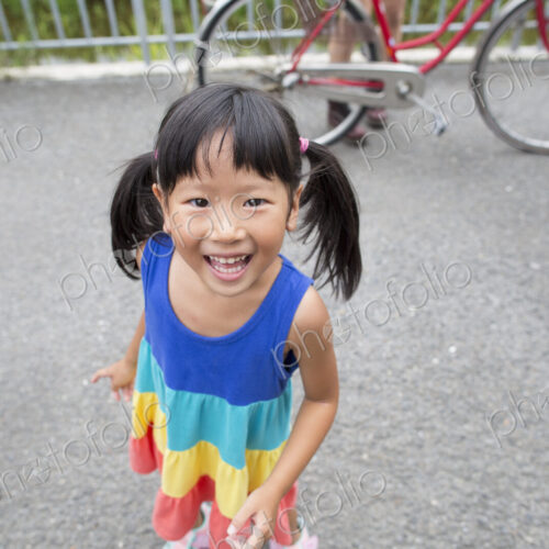 A young girl with pigtails smiling at the camera. A young girl with pigtails smiling at the camera.