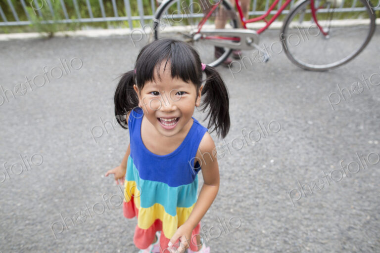 A young girl with pigtails smiling at the camera.