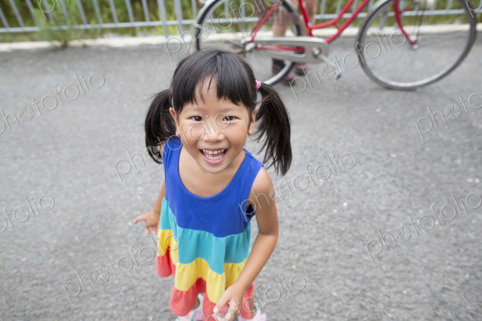 A young girl with pigtails smiling at the camera.