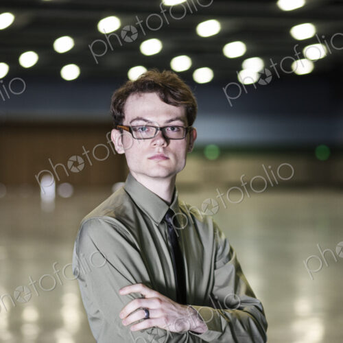 A young hip businessman standing in a dimly lit and dark exhibition area in a… A young hip businessman standing in a dimly lit and dark exhibition area in a…