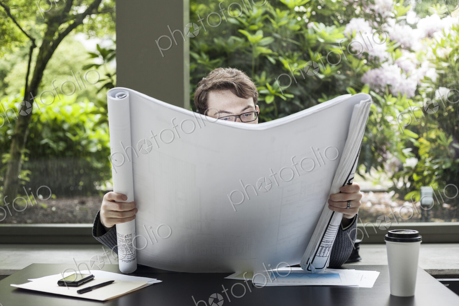 A young hip businessman working on architectural plans in his office.